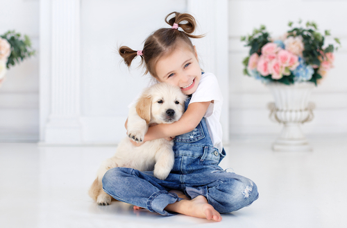 a girl sitting with a puppy